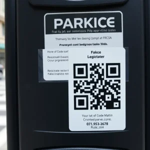 Parking meter with a fake QR code sticker in downtown Orlando