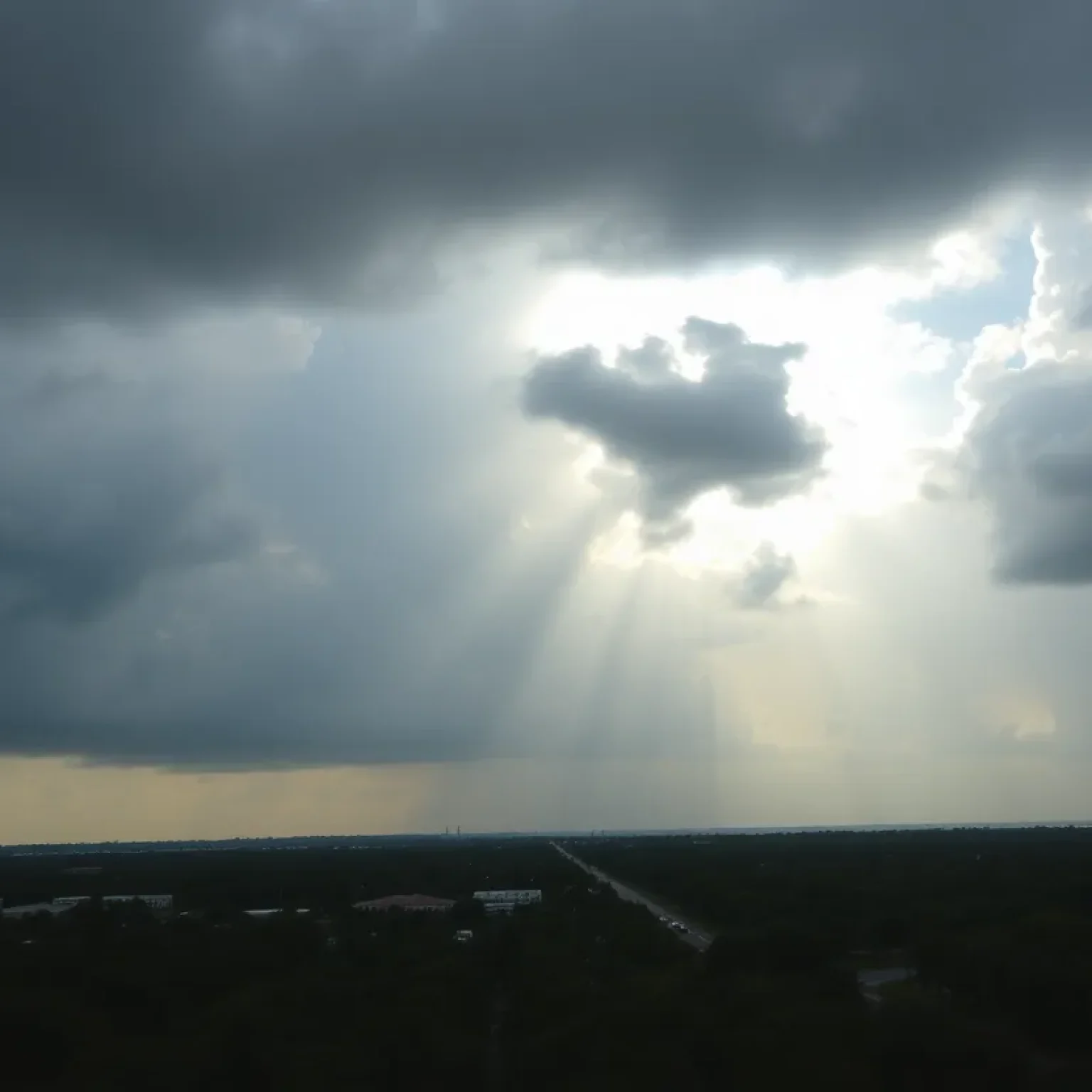 A cloudy sky over Orlando, Florida, showing rain and heat conditions.